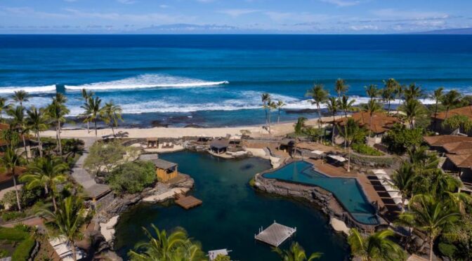 Aerial view of Four Seasons Resort Hualalai with oceanfront pools and lush greenery.