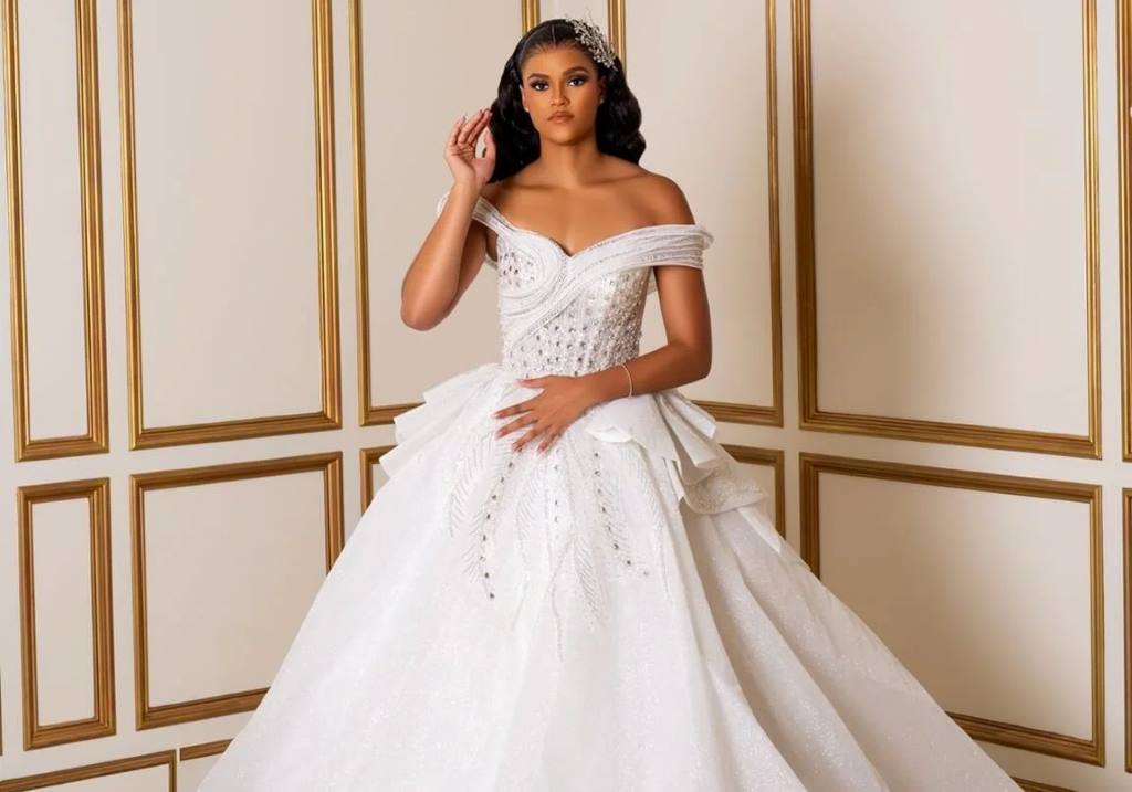 Bride in a lace basque waist wedding dress with cathedral-length veil.